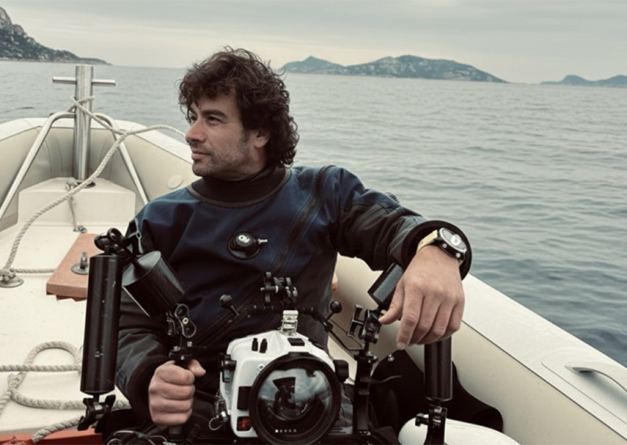 José Macías of Coral Soul on a boat at sea, holding an underwater camera rig